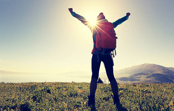 istock cheering successful woman backpacker open arms on mountain peak 580136136