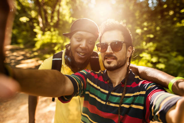 istock Two smiling hipster friends taking selfie in the park. 582257712