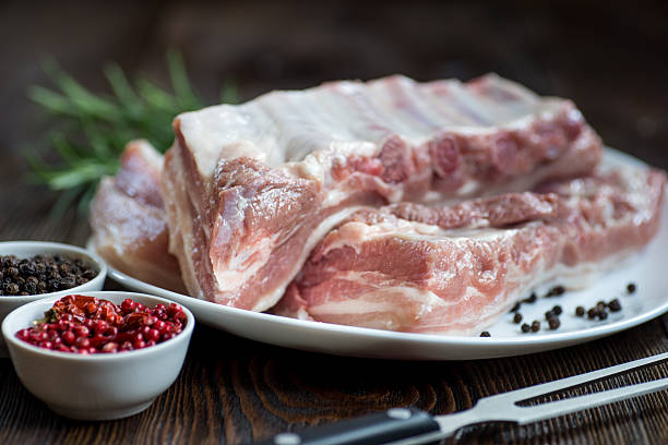 close up carne cruda de costilla de cerdo en plato blanco - rubbing spice rib barbecue fotografías e imágenes de stock