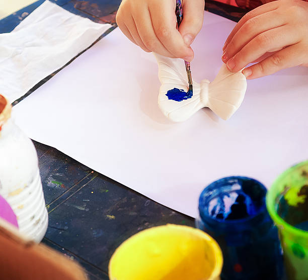 istock Girl paints a butterfly 582260454