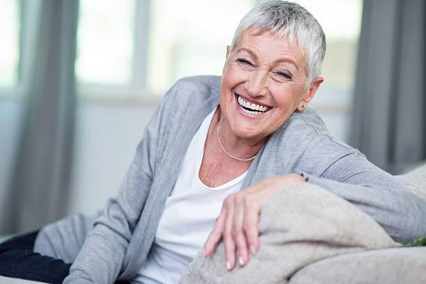 istock Cheerful senior woman sitting on a couch 582265908