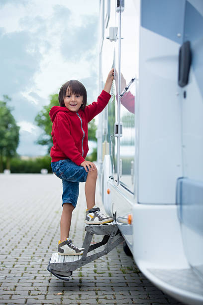 istock Cute kid, sitting on a doorway of a caravan 582268252