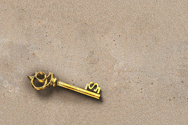 istock Discover gold treasure key in dollar shape inside dirty sand 582268292