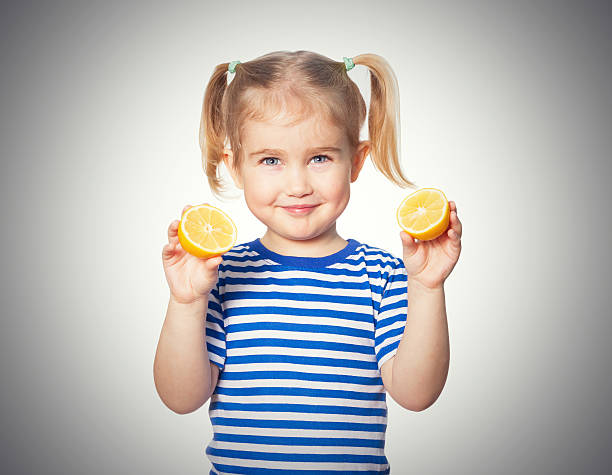 istock Little Funny girl keeps lemons 582268614