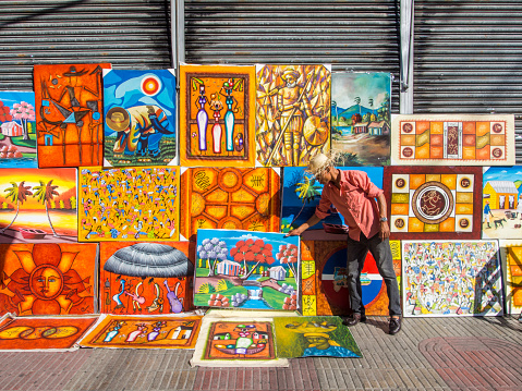 Santo Domingo, Dominican Republic - February 24, 2013: An artist selling his paintings by the street in Santo Domingo, Dominican Republic