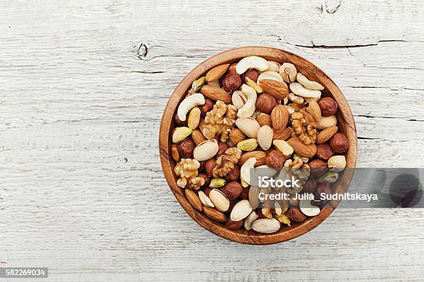 Photo libre de droit de Bol En Bois Avec Des Noix Noix Pistaches Amandes Noisettes Plat Lay banque d'images et plus d'images libres de droit de Fruit à coque