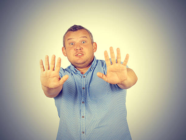 istock Fat man looking shocked scared trying to protect himself 582270766