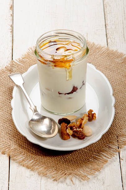 Cтоковое фото греческий йогурт с орехами и сладким медом в стакане