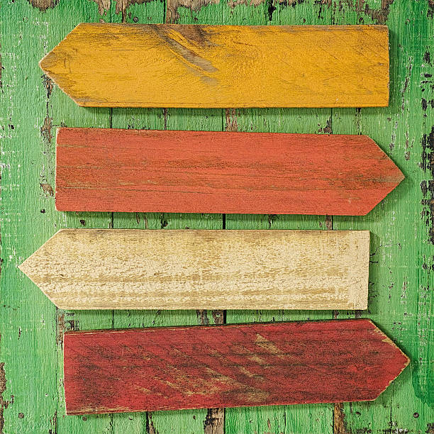 istock Old colourful weathered wood sign arrows. 582272286