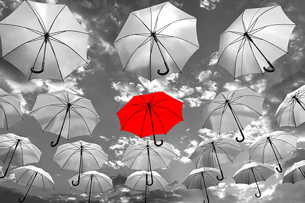 umbrella standing out from the crowd unique concept stock photo