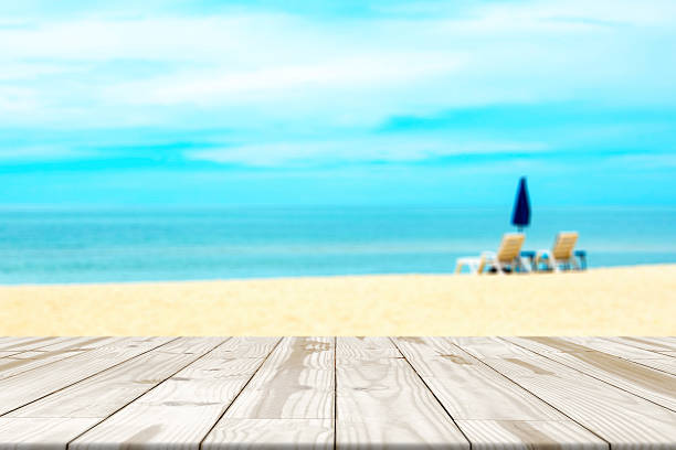 istock Wood table top on sea beach blurred in background 582277790