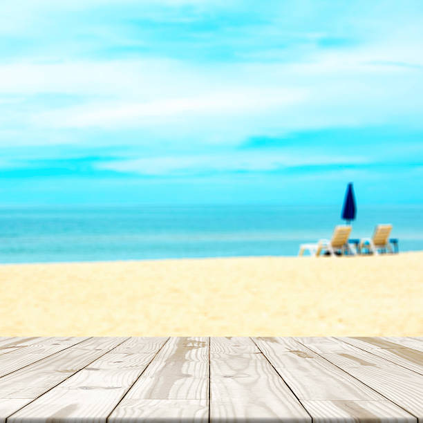 istock Wood table top on sea beach blurred in background 582277836