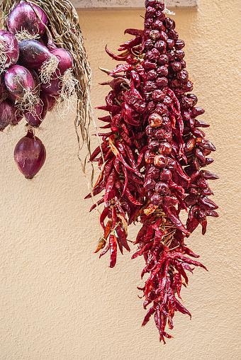 Bundles of red onion and red hot peppers hanging