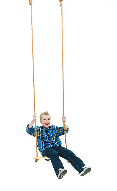 istock Smiling little boy swinging 582285136