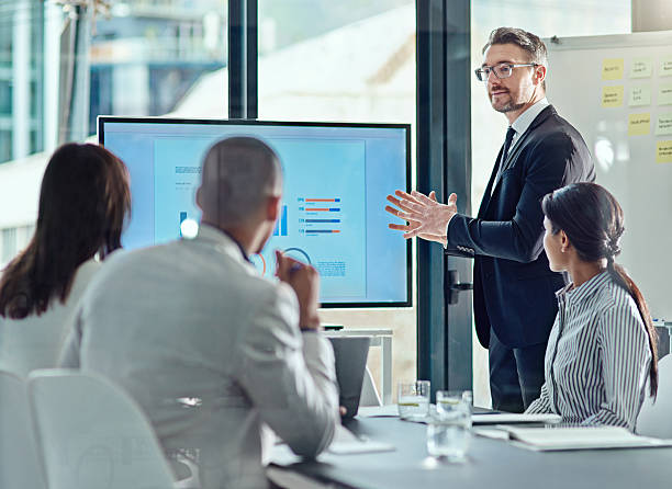 This is what we need to focus on now Cropped shot of a businessman delivering a presentation in the boardroom financial occupation stock pictures, royalty-free photos & images