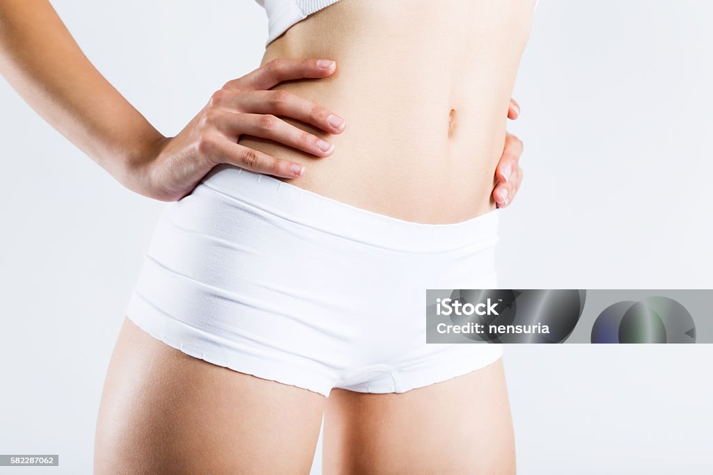 Slim tanned woman's body. Isolated on white background. Portrait of slim tanned woman's body. Isolated on white background. Dieting Stock Photo