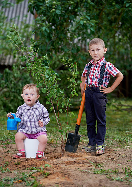 istock funny boy with shovel in garden 582287196