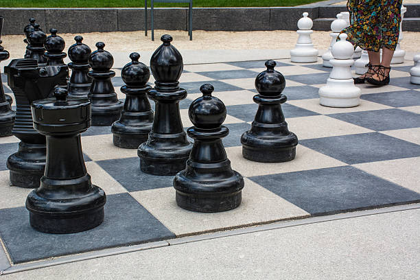 istock Black and white street chessmen with womans legs 582287372