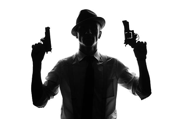 istock Silhouette of detective with two guns 582288376