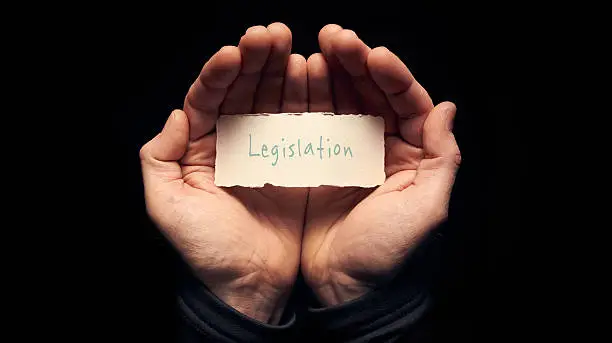 A man holding a torn piece of paper with a Legislation Concept