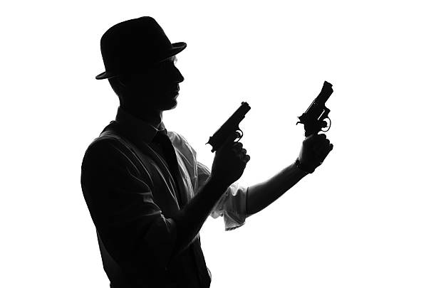 istock Silhouette of detective with two guns 582288428