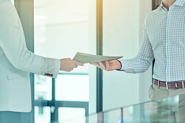 Doing a handover Shot of a businessman handing a document to a colleague passing giving stock pictures, royalty-free photos & images