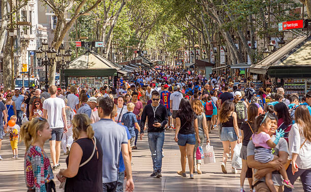 La Rambla in Barcelona, Spain Barcelona, Spain - July 5, 2016: Hundreds of people promenading in the busiest street of Barcelona, the Ramblas. The street extends 1.2 kilometers connects the Placa de Catalunya in the centre with the Christopher Columbus Monument at Port Vell. la rambla stock pictures, royalty-free photos & images