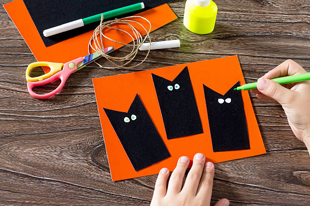 istock The child create a greeting card Halloween black cat out 582290824