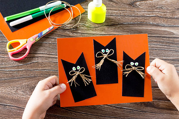 istock The child create a greeting card Halloween black cat out 582291170
