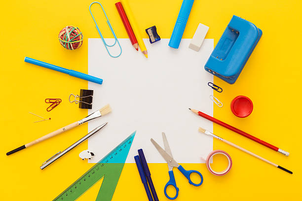 School supplies on yellow desk with copy space.Top view. Back to school. Colorful composition of school supplies: crayons, scissors, markers, globe, rulers, paints. Notebook in the center. Vibrant color background. yellow scissors stock pictures, royalty-free photos & images