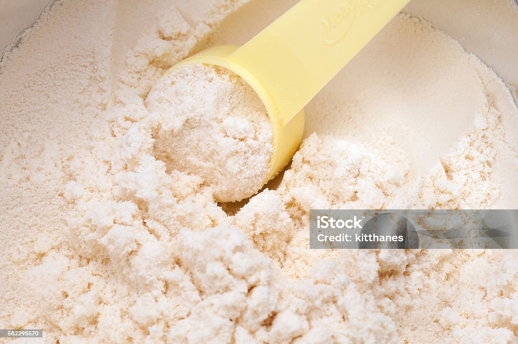 baby milk powder in cans that open with a spoon close up of powdered milk and spoon for baby on white background with clipping path Ground - Culinary Stock Photo