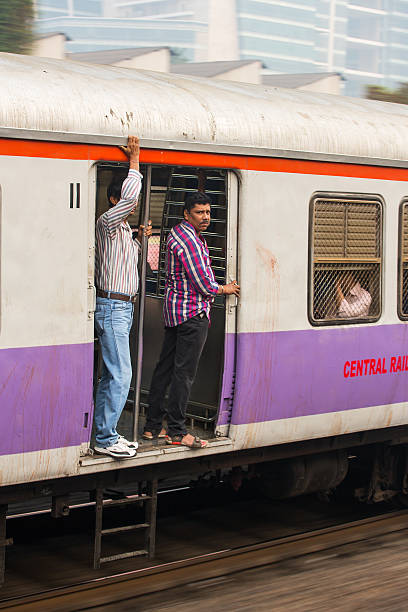 Unidentified men traveling via Suburban train in Mumbai, India. stock photo