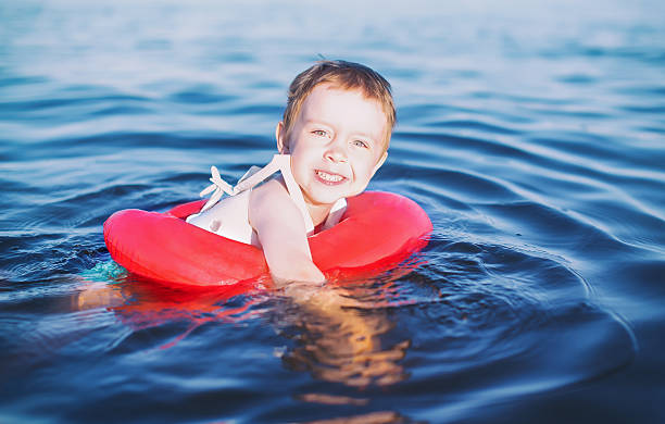 istock boy enjoys swimming with rubber ring 582302618