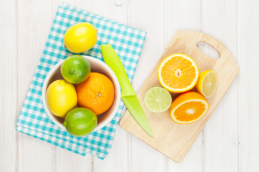 Citrus fruits. Oranges, limes and lemons. Over wooden table background