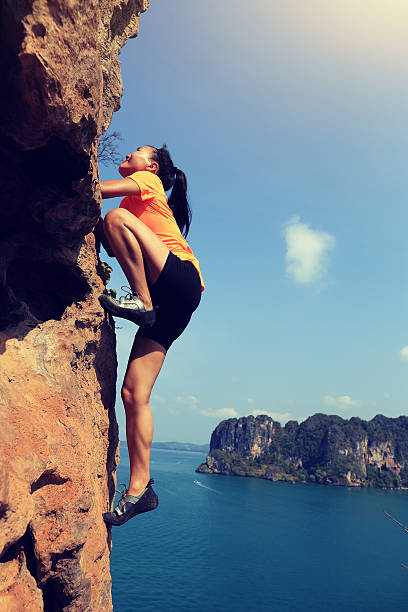 istock young woman rock climber climbing at seaside mountain rock 582305598