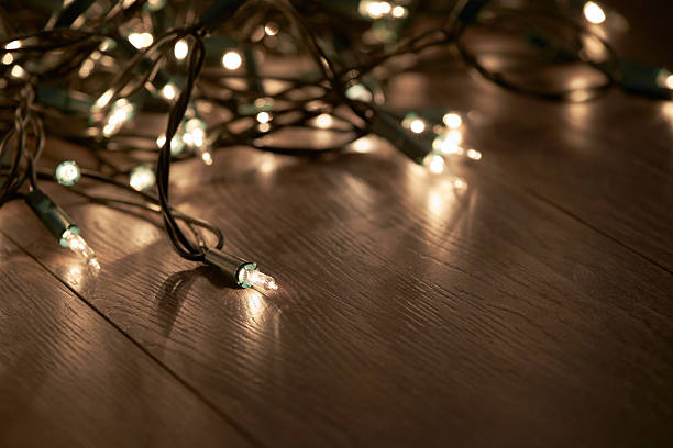 luzes tradicionais da árvore de natal deitadas em um chão de madeira. - 25th street - fotografias e filmes do acervo