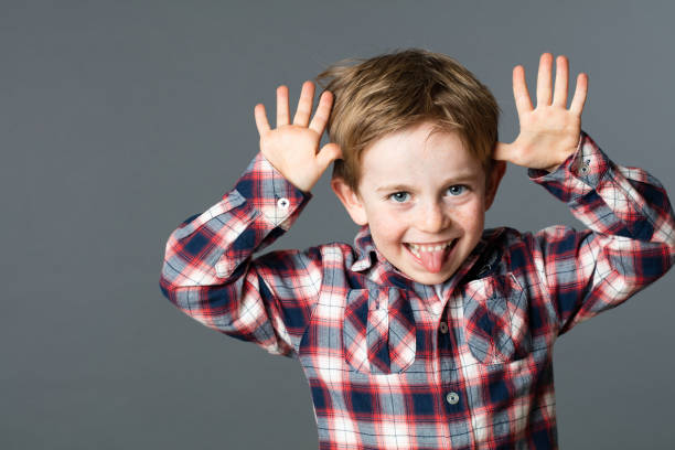 istock young child enjoying making a funny face, sticking out tongue 582307308
