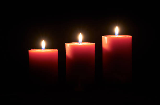 istock Red candle on a dark wooden floor. 582308092