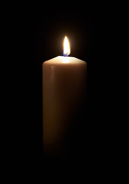 istock White candle on a dark wooden floor. 582308248