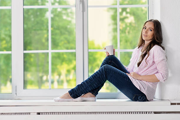 istock Happy young woman with tea 582308628