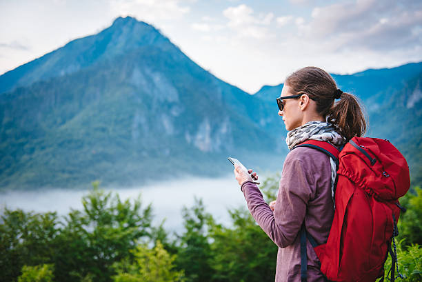 istock Woman hiking on the mountain and using smart phone 582309182