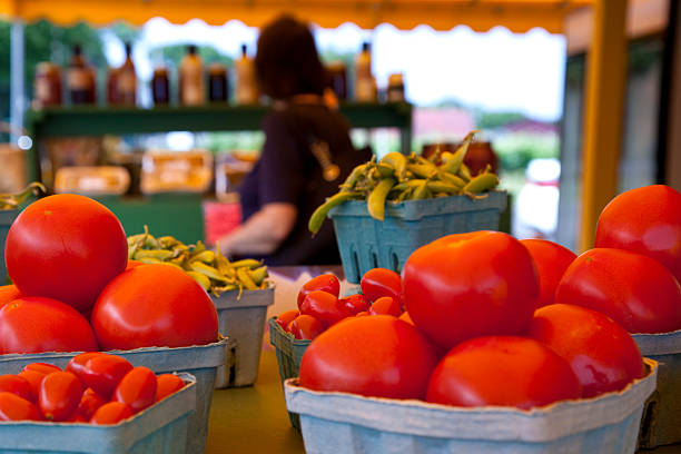 istock Tomatoes at road side vegetable stand with unrecognizable woman shopping 582310024