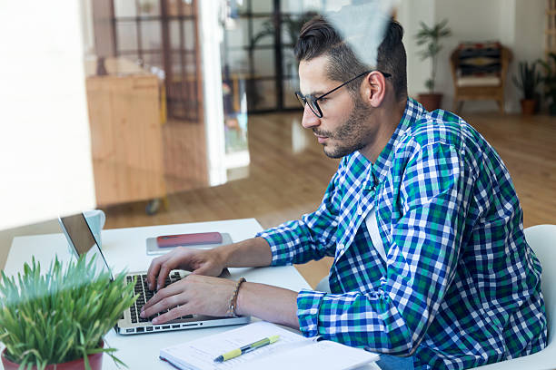 istock Handsome young man working with laptop at home. 582311878