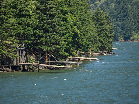 Stevenson, Washington, USA - June 29, 2016: Indian fishing platforms on the shore of the Columbia River in Washington State. This photo with tree and river background is near Stevenson, Washington. The wood fishing platforms are legal for Indians due to treaty fishing rights. The area around Bonneville Dam has a number of platforms of all ages used by the Washington and Oregon Native American Indians.