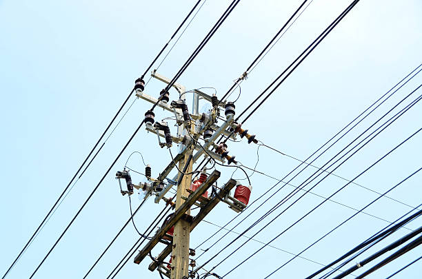 istock Electrical pole with power lines against hazy blue sky 582313956
