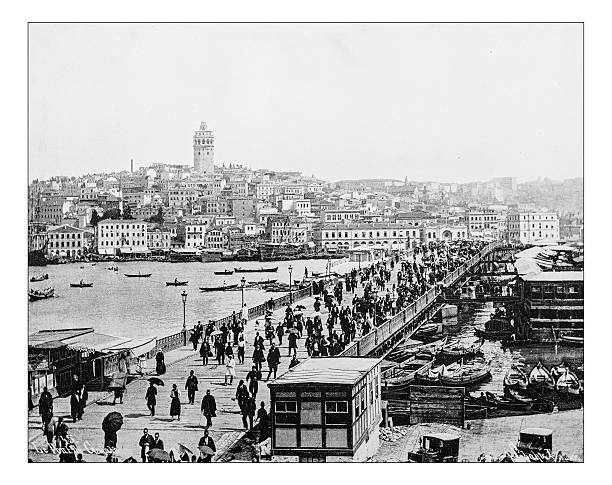 Antique photograph of Istanbul and Bosphorus bridge (Turkey,19th century) Antique photograph of panorama of Istanbul and Galata bridge (Turkey) in a19th century picture, taken from the other side of the Bosphorus strait (between the Sea of Marmara and the Black Sea). In the picture we can see the crowded Galata bridge crossing the Strait and on the background the, the Galata/Karaköy quarter of Istanbul with the medieval Galata Tower. Istanbul city centre is partially listed as a UNESCO World Heritage Site galata photos stock illustrations