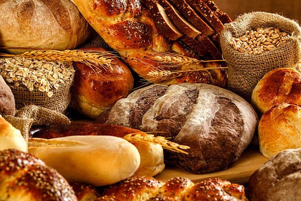 кустарная пекарня: свежая смешанная булочка, булочки и закваска хлеб - soda bread bread brown bread loaf of bread стоковые фото и изображения
