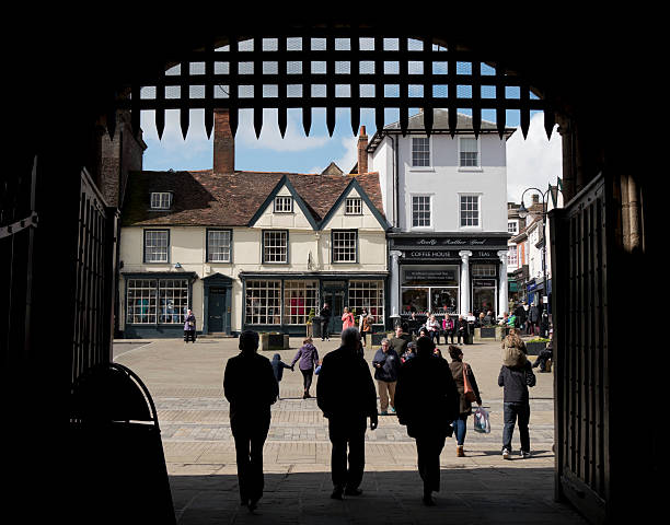 People passing through Abbey Gate, Bury St Edmunds Bury St Edmunds, Suffolk, England - April 17, 2016: People passing through the Abbey Gate into the town centre of Bury St Edmunds, in Suffolk, eastern England. Bury St Edmunds is an ancient town, built around the Abbey which housed the shrine of King Edmund (St Edmund) and became a place of medieval pilgrimage. Today it is a popular place for tourists to explore and a thriving commercial centre for local people. bury st edmunds stock pictures, royalty-free photos & images