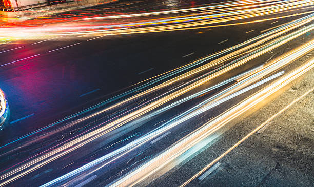 colorful long exposure light trails across road junction, traffic abstract - rush hour flash imagens e fotografias de stock