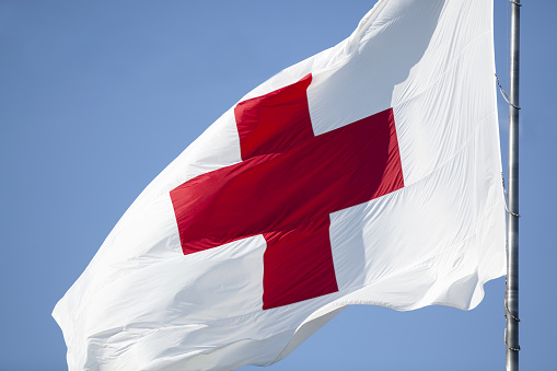 Madison, Wisconsin, United States - July 27, 2016: The flag of the Internation Red Cross disaster and humanitarian relief organization flies over their Madison, Wisconsin headquarters.